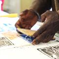 Revealed 2017 Professional Development - Print making. Photo by Jessica Wyld. Two hands lifting a printing block on paper.