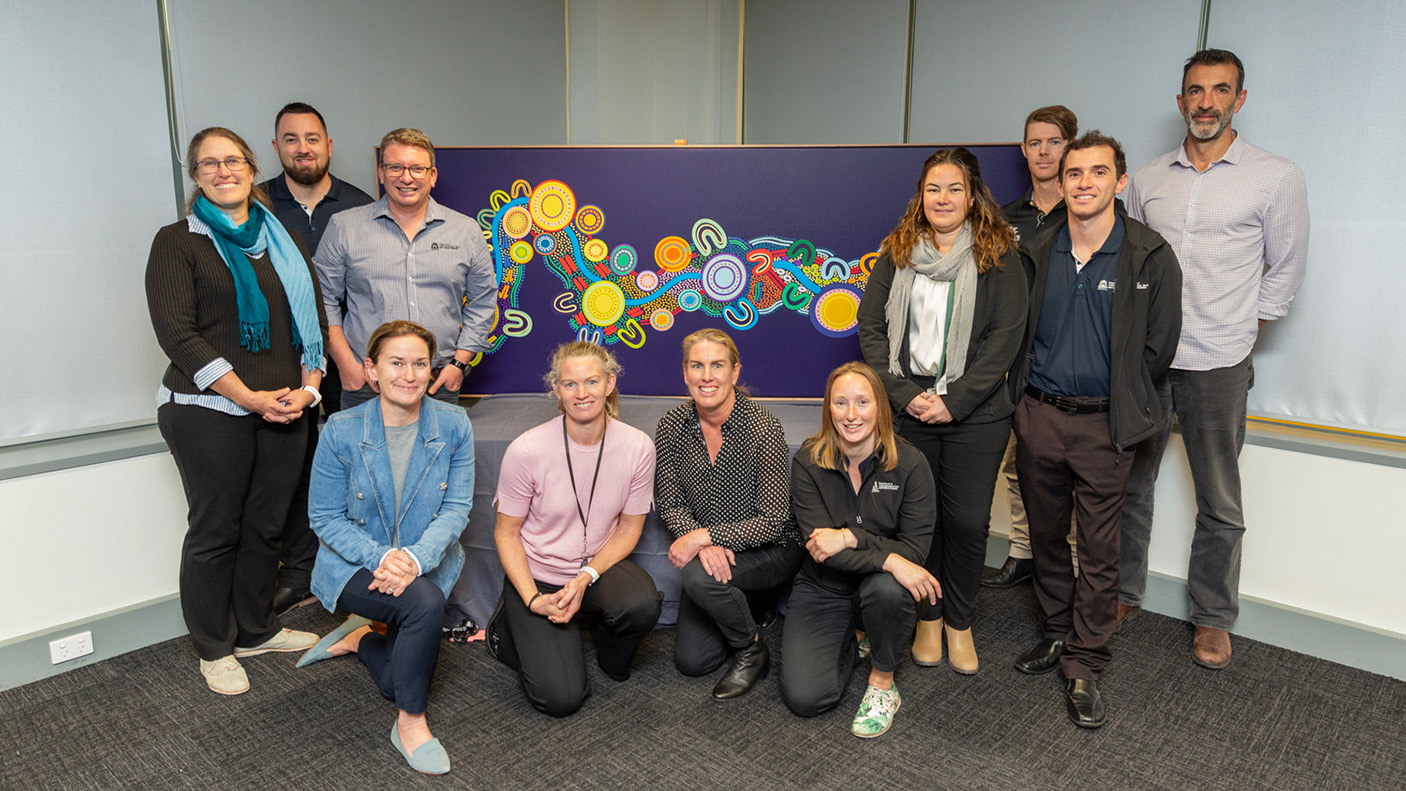 Regional DLGSC staff in front of an Aboriginal artwork
