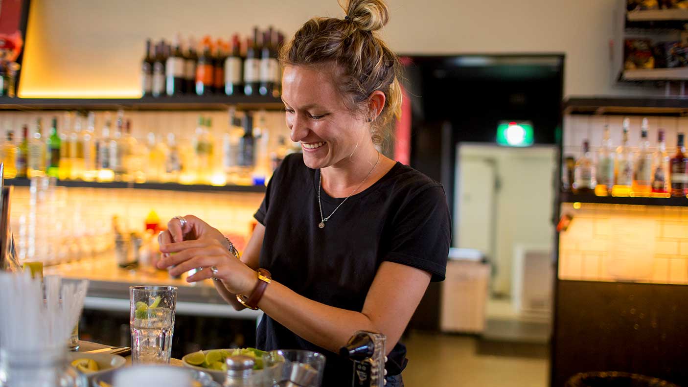 A bartender making drinks at a pub