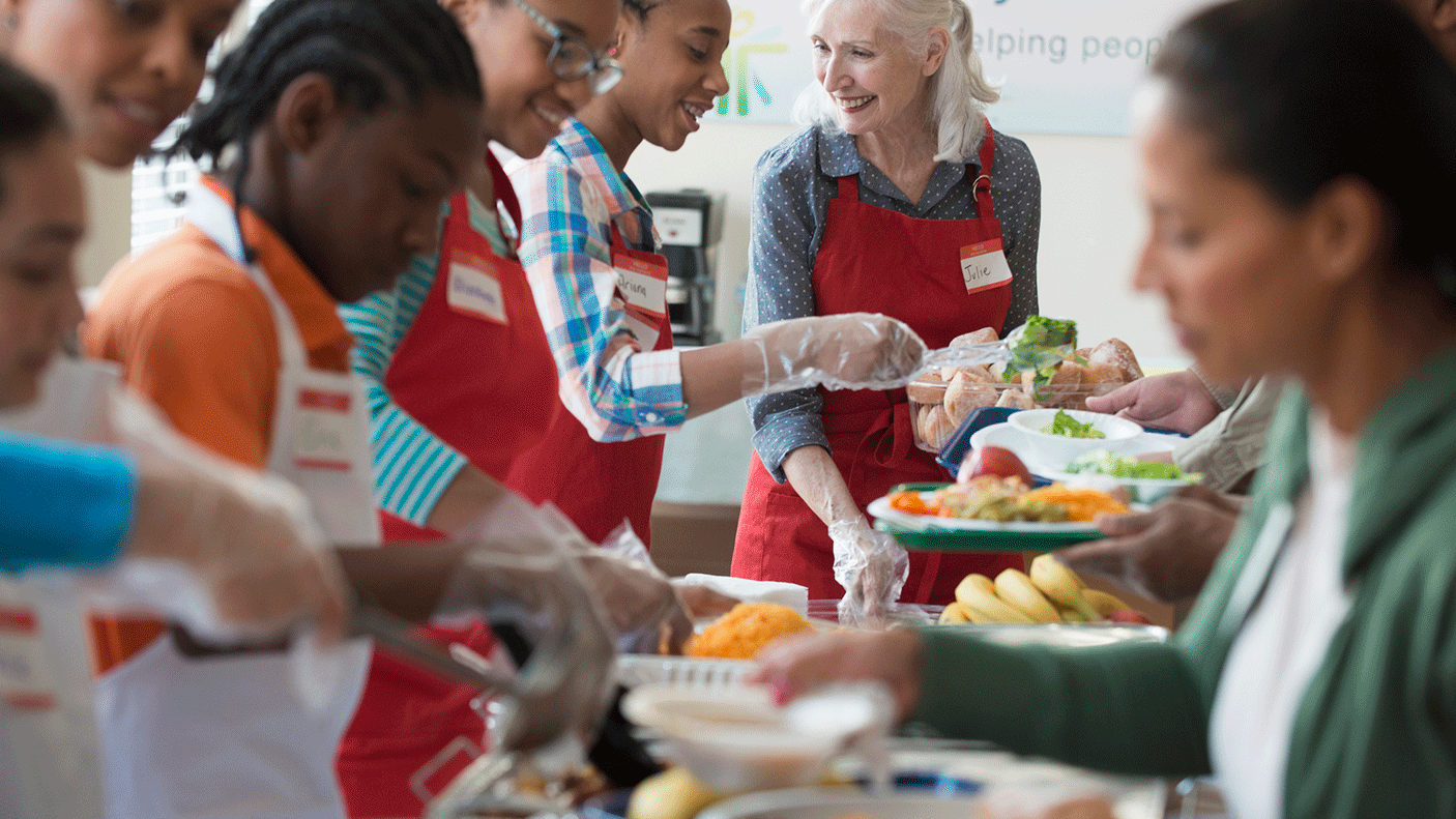 A group of volunteers serve food to people in a club