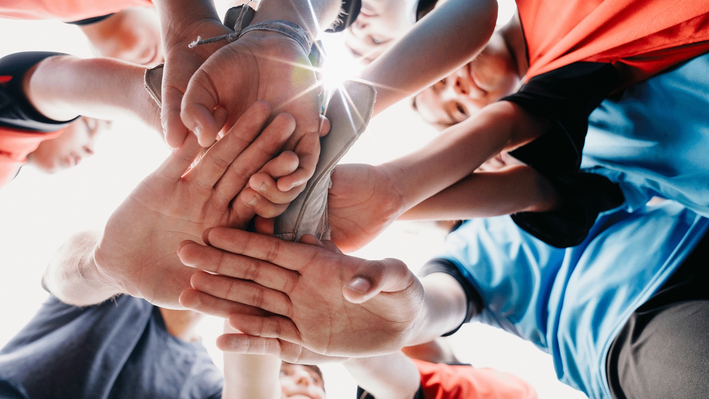 A close up of a group of hands, of a sporting team, stacked.